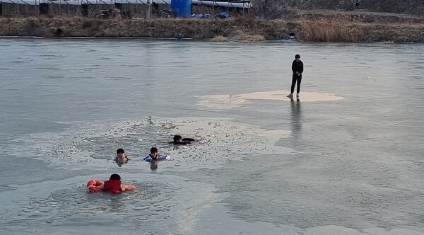 직산119안전센터 소방대원이 저수지에 빠진 중학생들을 구조하기 위해 얼음을 깨치며 다가가고 있다.  / 사진 충남소방본부